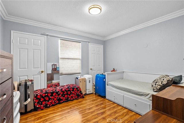 bedroom featuring crown molding and wood finished floors