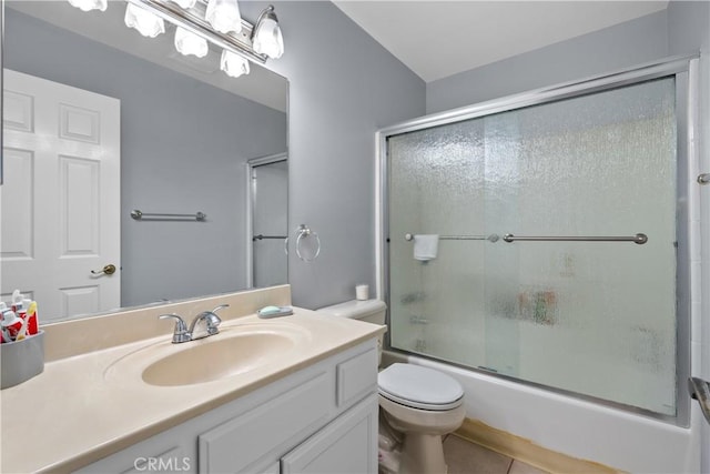 full bath featuring toilet, shower / bath combination with glass door, tile patterned flooring, and vanity