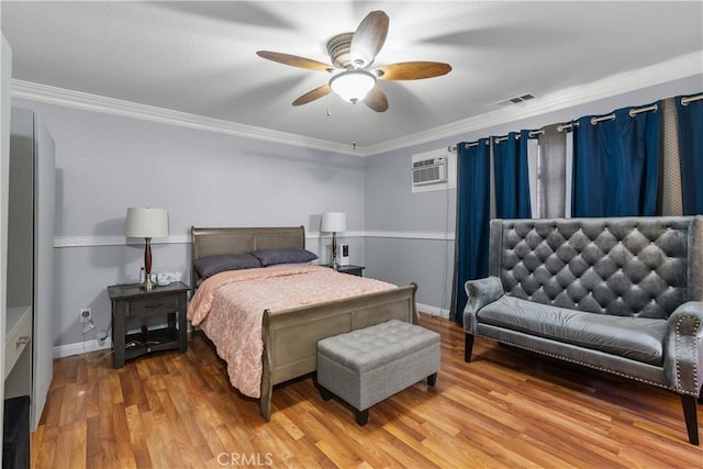 bedroom with light wood finished floors, visible vents, crown molding, and an AC wall unit