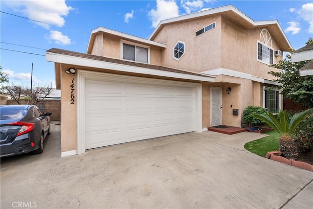 view of front of house featuring driveway, an attached garage, and stucco siding