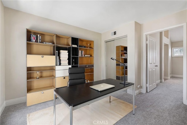 unfurnished office featuring carpet flooring, visible vents, and baseboards