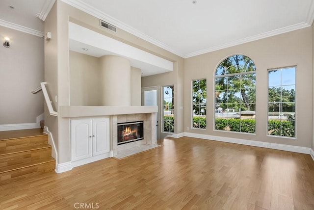 unfurnished living room with light wood-type flooring, visible vents, and baseboards