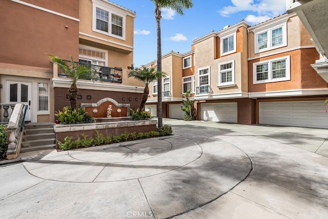 townhome / multi-family property with driveway, an attached garage, and stucco siding