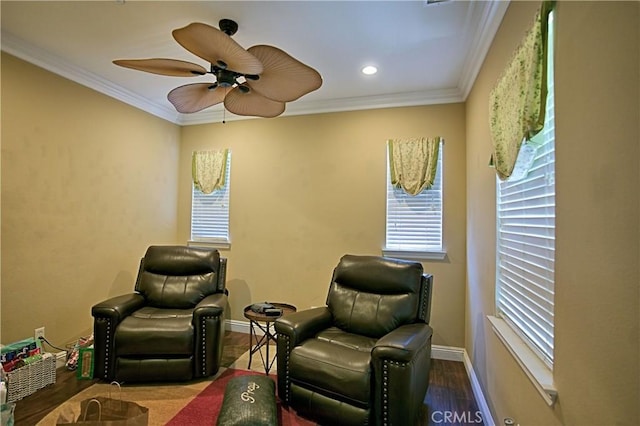 sitting room featuring a ceiling fan, crown molding, baseboards, and wood finished floors