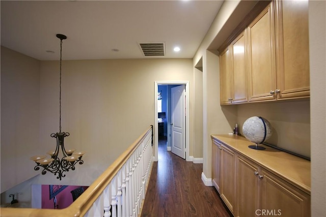 hall with baseboards, visible vents, dark wood-type flooring, an inviting chandelier, and recessed lighting