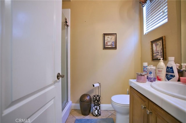 bathroom with toilet, a stall shower, vanity, tile patterned flooring, and baseboards