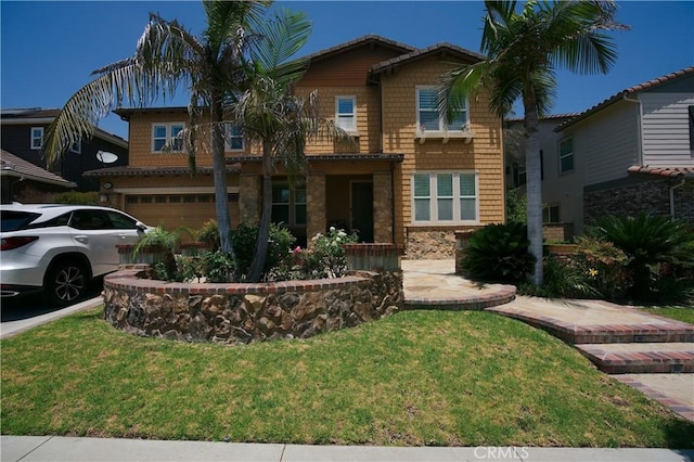 view of front of property with a garage, stone siding, and a front yard