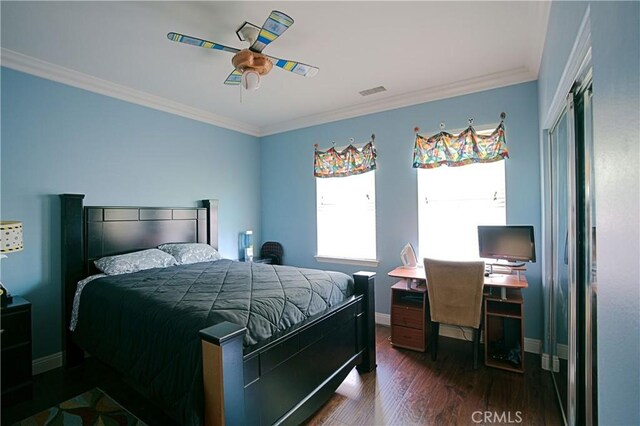 bedroom with dark wood-type flooring, visible vents, baseboards, a ceiling fan, and crown molding