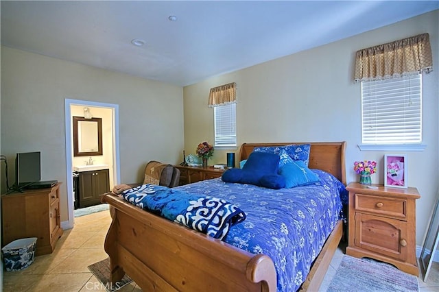 bedroom with light tile patterned floors and connected bathroom