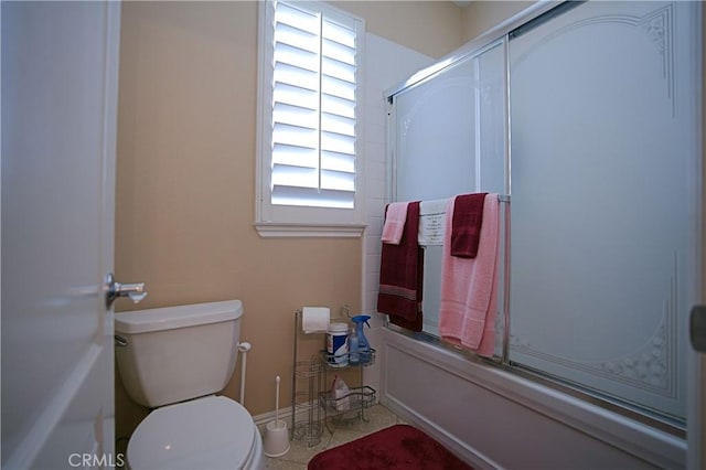 full bathroom with toilet and shower / bath combination with glass door