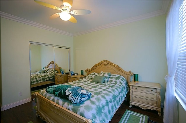 bedroom featuring baseboards, a closet, wood finished floors, and crown molding