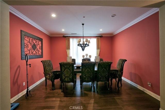 dining room with baseboards, wood finished floors, and crown molding