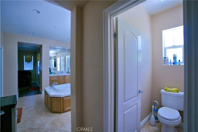 bathroom with toilet, tile patterned flooring, baseboards, and vanity