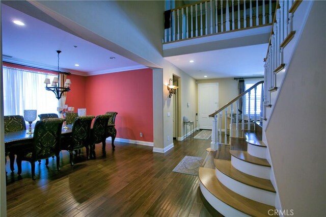 dining space with recessed lighting, stairway, an inviting chandelier, wood finished floors, and baseboards