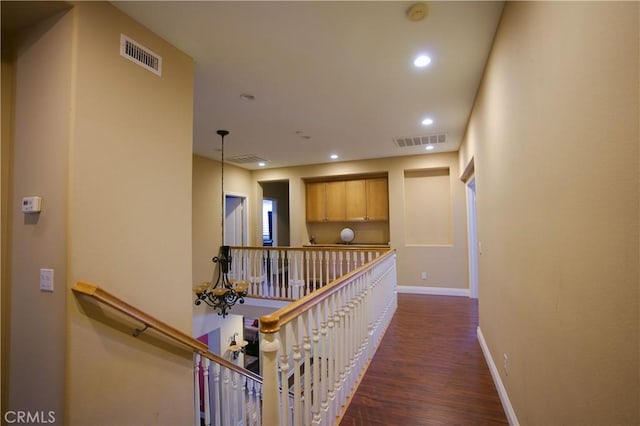 hallway featuring an upstairs landing, visible vents, and recessed lighting