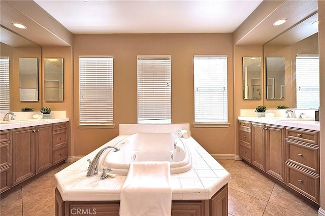 full bathroom featuring a whirlpool tub, tile patterned floors, two vanities, and plenty of natural light
