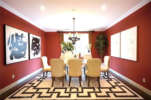 dining space featuring ornamental molding, a notable chandelier, baseboards, and wood finished floors