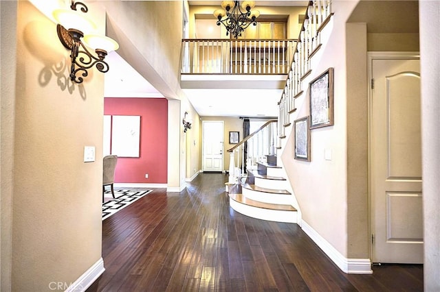 entryway featuring hardwood / wood-style flooring, baseboards, and a chandelier