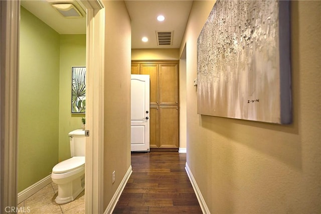 corridor with baseboards, visible vents, recessed lighting, and wood finished floors