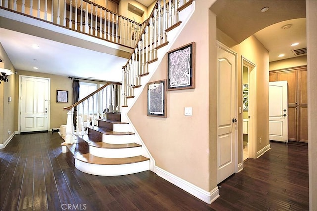 stairs with wood-type flooring, baseboards, and visible vents