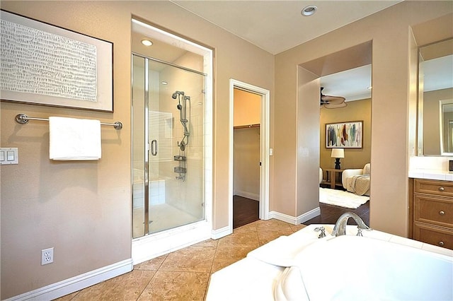 bathroom featuring a stall shower, baseboards, tile patterned flooring, and vanity