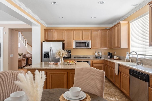 kitchen featuring recessed lighting, a sink, ornamental molding, stainless steel appliances, and a center island