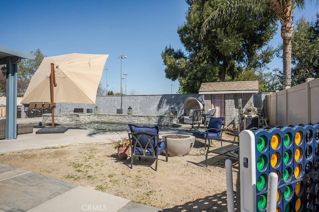 view of patio / terrace with an outdoor fire pit and fence