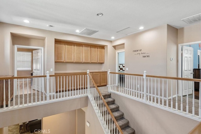 stairs with visible vents, recessed lighting, and attic access