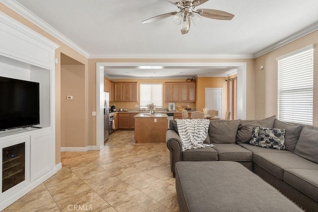 living room featuring baseboards, ceiling fan, and crown molding