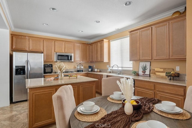 kitchen with an island with sink, recessed lighting, a sink, ornamental molding, and stainless steel appliances