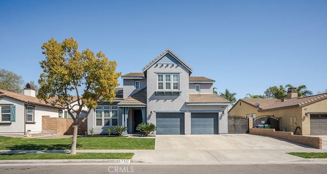 view of front of house featuring a front lawn, a gate, fence, concrete driveway, and an attached garage