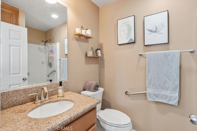 bathroom featuring tiled shower, toilet, and vanity