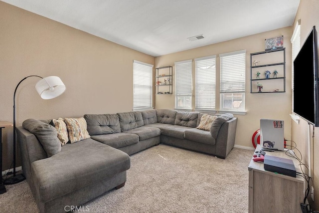 carpeted living area featuring visible vents and baseboards