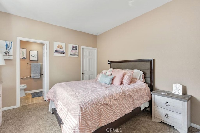 carpeted bedroom featuring baseboards and connected bathroom