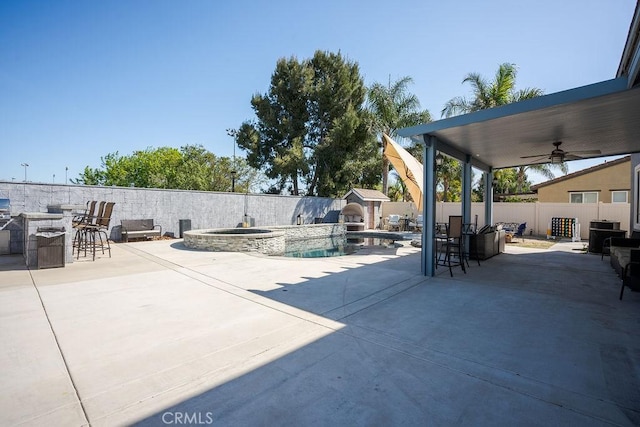 view of patio featuring ceiling fan, an outdoor fire pit, a fenced backyard, and a fenced in pool