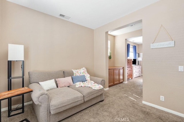 living area featuring light carpet, visible vents, and baseboards