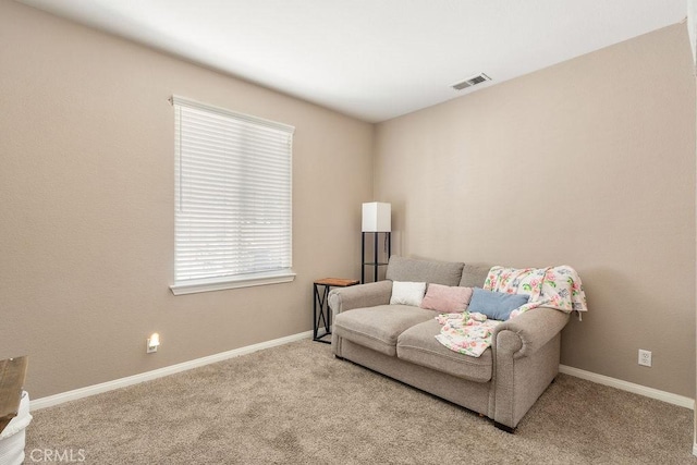 living area with baseboards, visible vents, and carpet floors