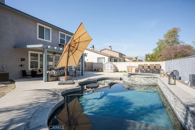 view of swimming pool featuring an outdoor living space, a pool with connected hot tub, a fenced backyard, a patio area, and a ceiling fan