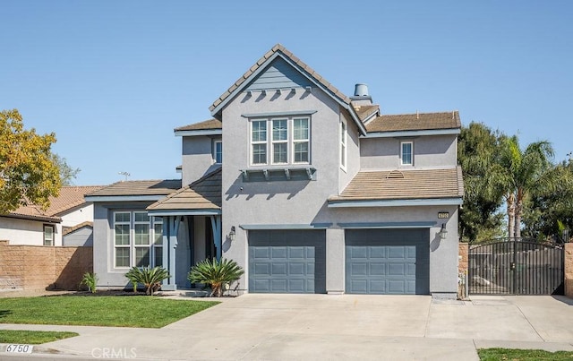 traditional-style house featuring an attached garage, fence, stucco siding, driveway, and a gate