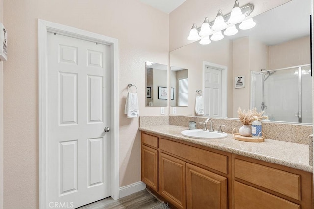 bathroom with vanity, wood finished floors, and a shower stall