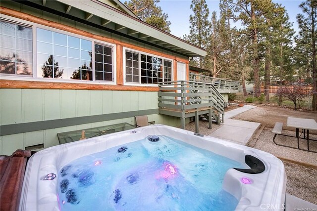 exterior space with an outdoor hot tub and a patio