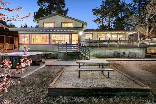 rear view of property featuring stairs and a patio