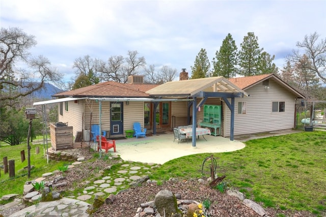 back of house with a patio area, a chimney, central AC unit, and a lawn