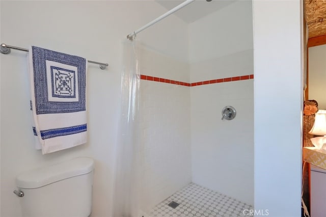 bathroom with a shower stall and toilet