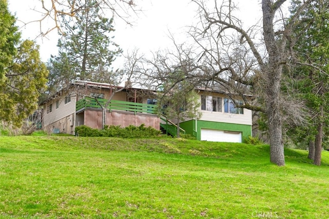 back of property with a garage and a yard