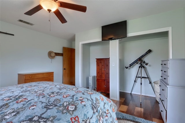 bedroom with ceiling fan, radiator heating unit, wood finished floors, and visible vents