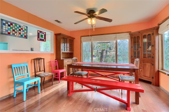 dining room featuring a ceiling fan, light wood-type flooring, visible vents, and baseboards