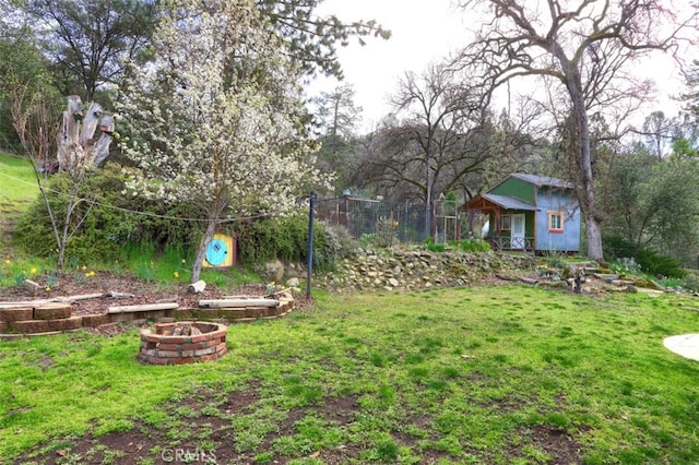 view of yard with a fire pit and an outbuilding