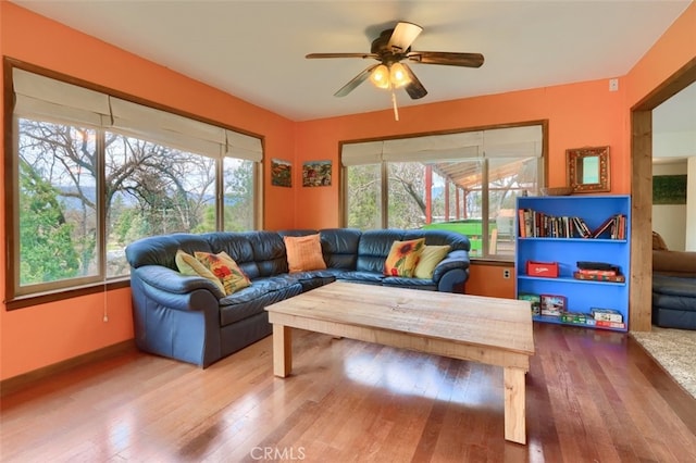 living area featuring a healthy amount of sunlight, a ceiling fan, and hardwood / wood-style floors