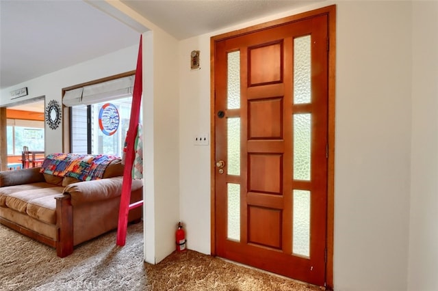 foyer entrance featuring carpet flooring